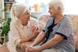 A happy image image of Airmid Staffing carer supporting a client at home Person-Centred Care. Personal care, respite care, palliative care, live in care.